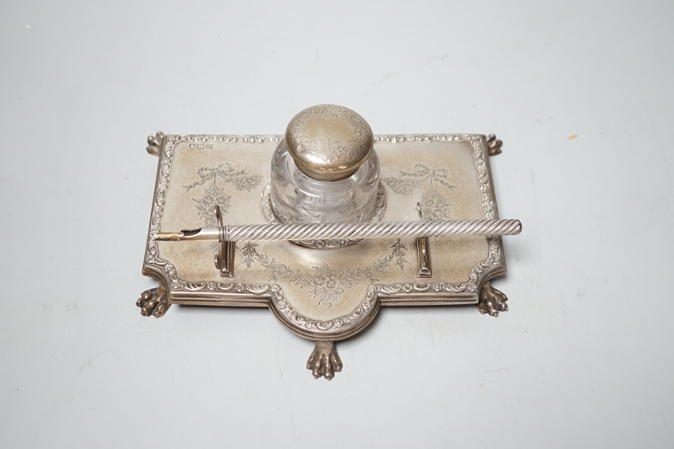 An Edwardian silver inkstand, with mounted glass well, on paw feet, maker's mark rubbed, London, 1909, 18.8cm, together with an associated S. Mordan & Co dip pen.